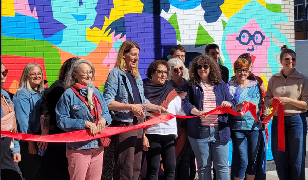 Inauguration la murale. La mairesse Véronique Fournier coupe le ruban parmi les artistes, les organisateur.trice.s et artistes